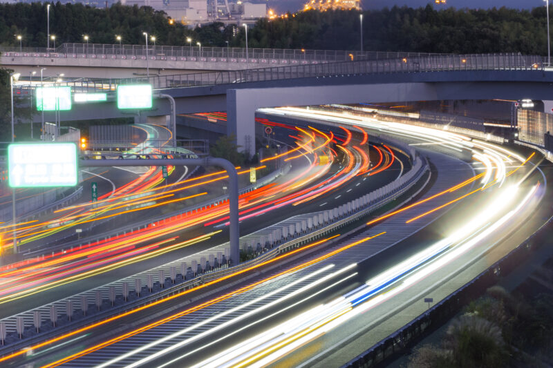 夜の四日市ジャンクションを行き交う車の光跡